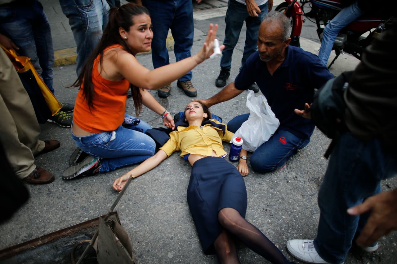 Varias mujeres han resultado heridas en las refriegas, como esta que es atendida por sus compañeros en una calle de Caracas. 20 de abril de 2017.