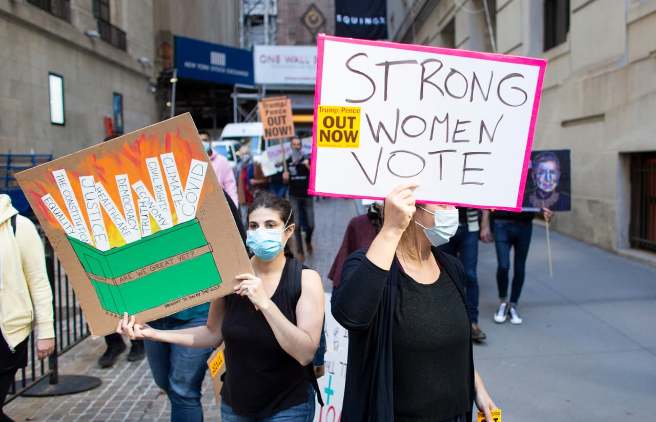 En esta imagen, manifestantes marchan por las calles de Nueva York, con un letrero que dice 
<b>"Las mujeres fuertes votan".</b>