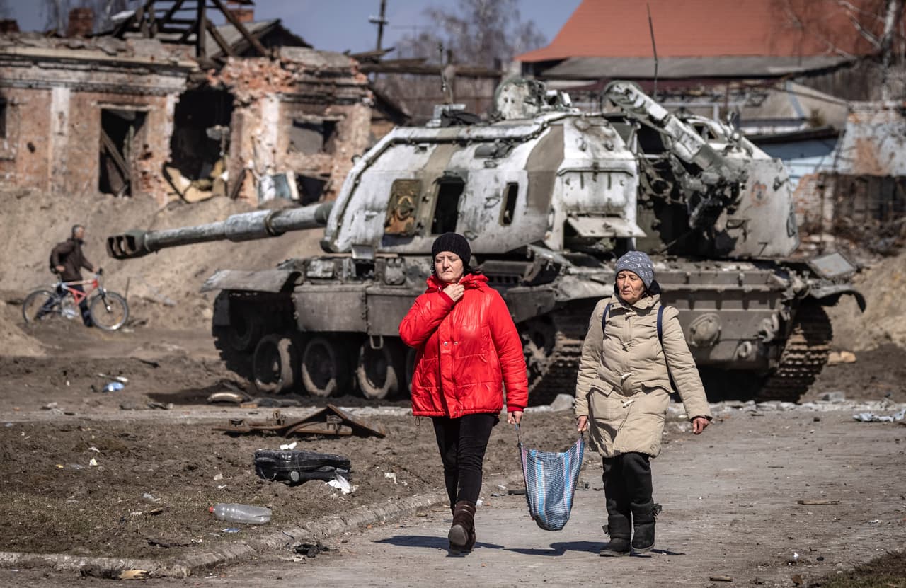 Residentes pasan frente a un tanque ruso destruido en la ciudad nororiental de 
<b>Trostianets, situada a unas 40 millas por carretera de la frontera con Rusia. </b>
<br>
<br>
