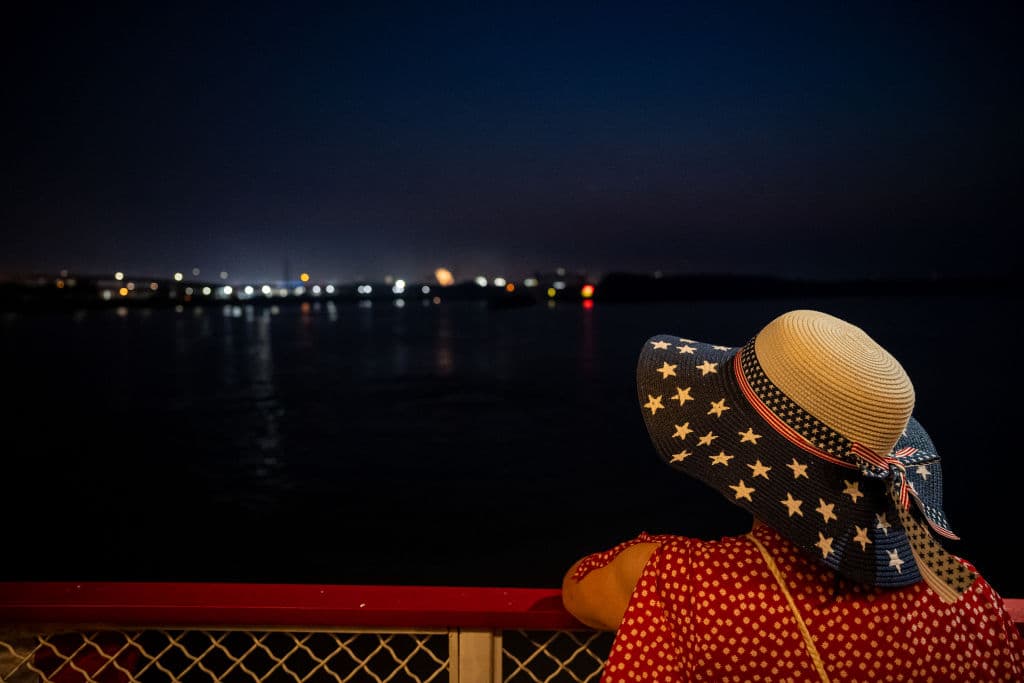 Una mujer con un sombrero decorado con la bandera de EEUU contempla los fuegos artificiales desde el histórico barco de vapor 
<b>Belle of Louisville, en Kentucky. </b>