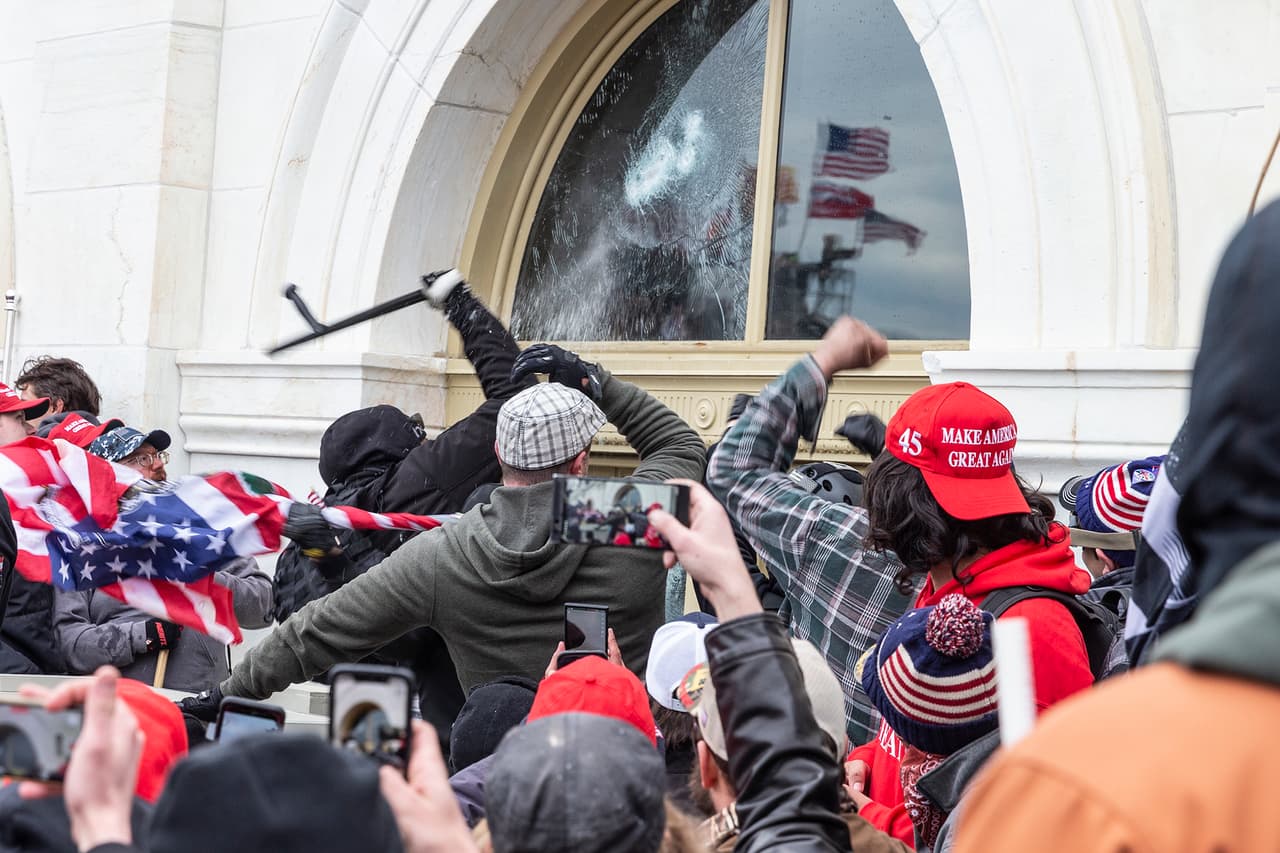 Uno de los momentos en el que la multitud golpeaba las ventanas de cristal para abrirse paso y entrar al Congreso estadounidense.