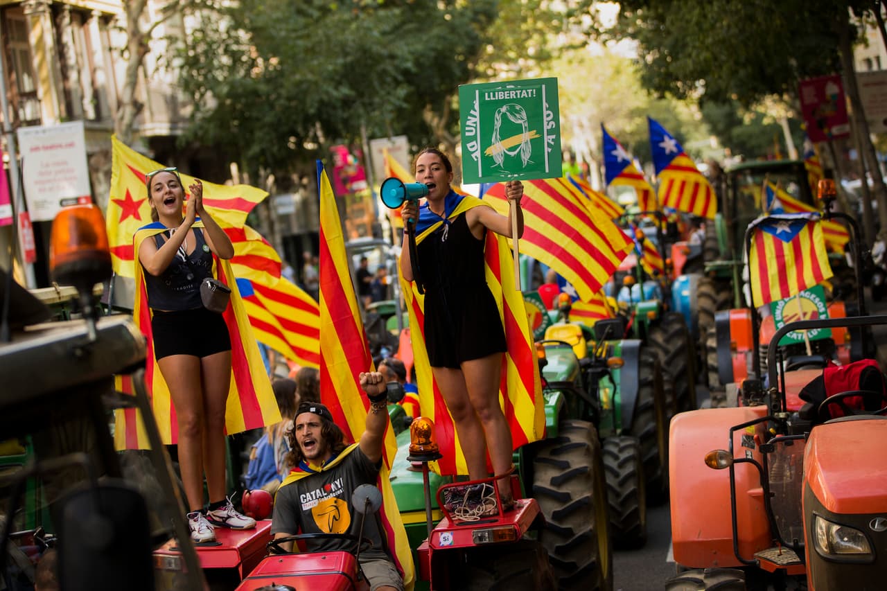Montados sobre unos tractores que circularon por varias calles de Barcelona estos activistas por el 'si' invitaron a votar en el referéndum de este domingo.