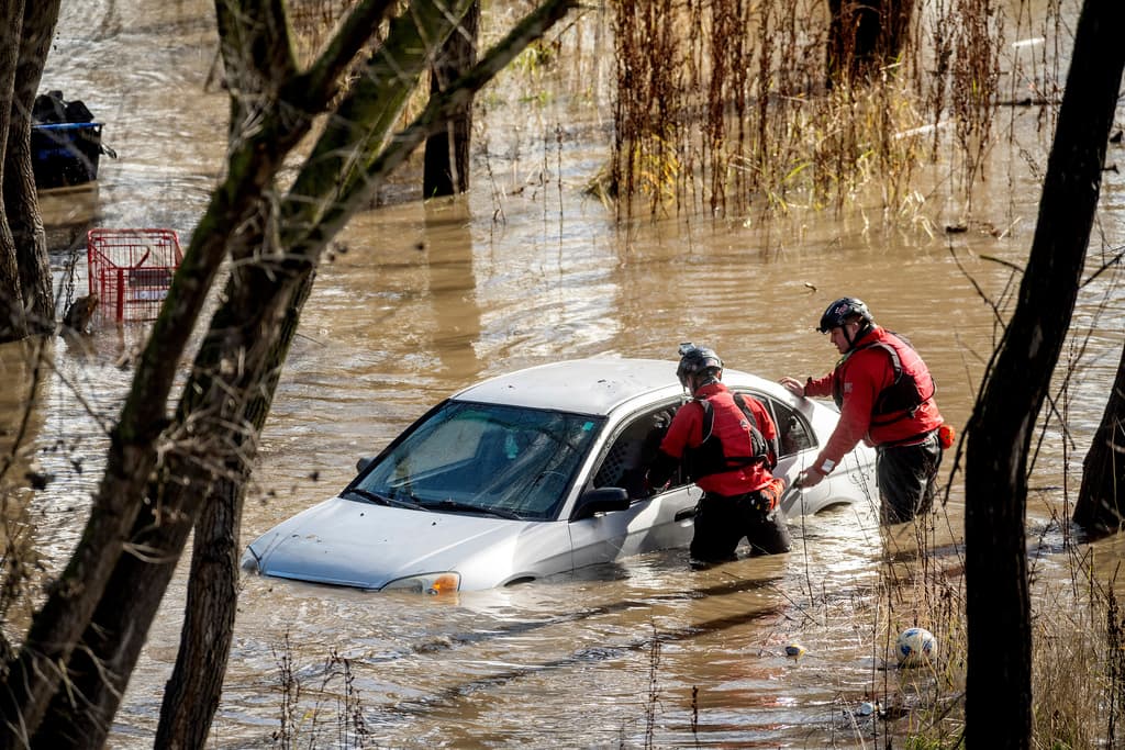Los trabajadores de búsqueda y rescate investigan un automóvil rodeado por agua inundada cuando las fuertes lluvias causaron el aumento del río Guadalupe, el domingo 4 de febrero de 2024, en San José, California. El vehículo estaba deshabitado. (Foto AP/Noah Berger)