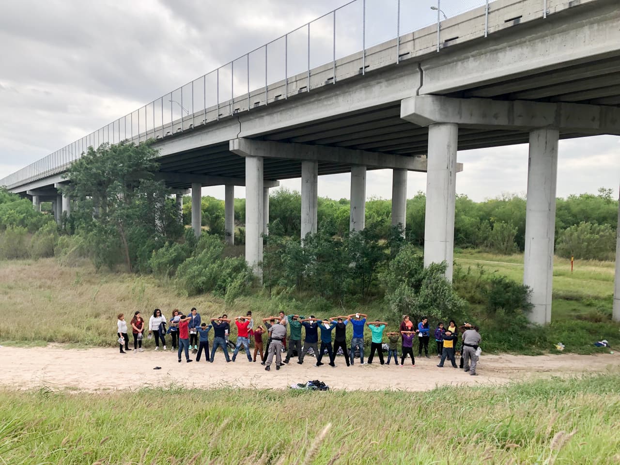Unas horas después de que llegaran los primeros migrantes a la zona de Rincon Landing, aparecen varios autobuses y camionetas de una empresa subcontratada. Después de cachear a los hombres y a los niños varones, los empleados pasan lista de los próximos que llevarán al centro de procesamiento de la Patrulla Fronteriza.