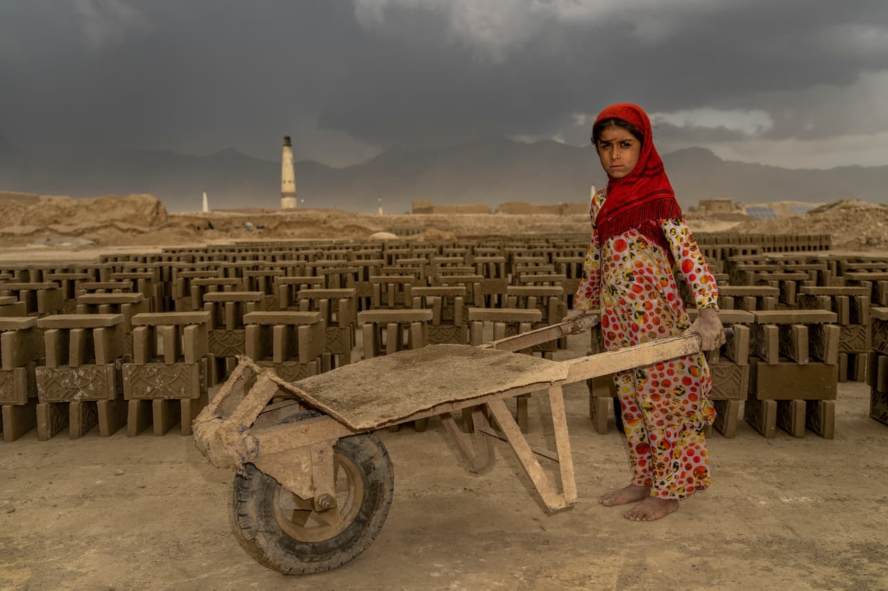 En la foto, una niña afgana de 9 años trabaja en una fábrica de ladrillos.
<br>
<br>En los hornos de ladrillos,
<b> los niños hacen cada paso del proceso de fabricación. </b>Acarrean bidones de agua, cargan los moldes de ladrillos de madera llenos de barro para ponerlos al sol a secar. 
<b>Cargan y llevan carretillas de ladrillos secos al horno para cocerlos y luego empujan carretillas llenas de ladrillos cocidos. </b>
<br>