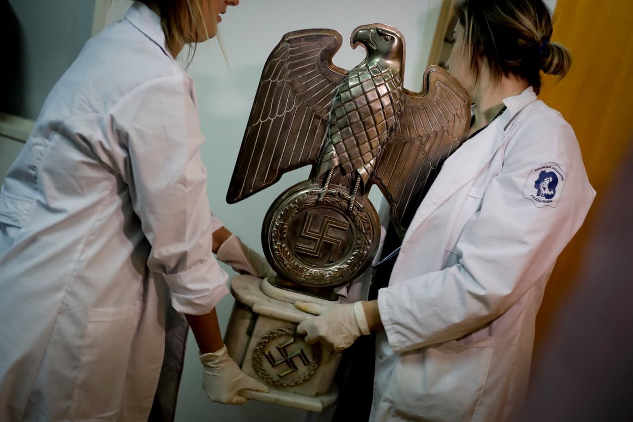 Funcionarios cargan una estatua de un Águila con la esvástica nazi.