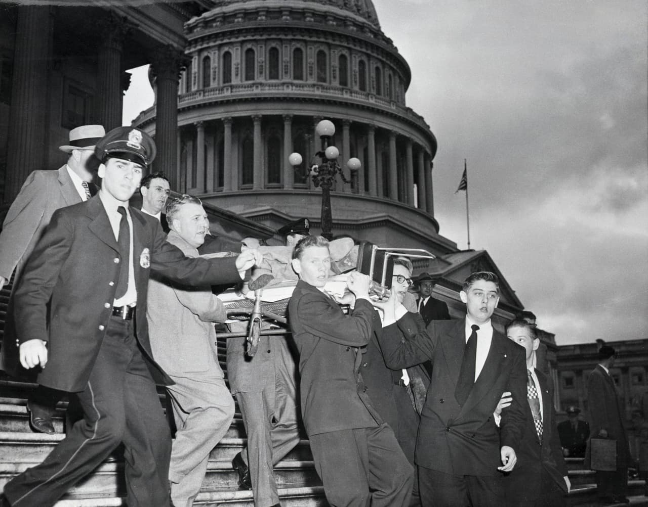 <b>El tiroteo nacionalista puertorriqueño (1 de marzo de 1954)</b>
<br>
<br>Cuatro activistas por la independencia de Puerto Rico entraron armados a la Cámara de Representantes, dispararon contra los congresistas y dejaron a cinco heridos. 
<br>
<br>Uno de ellos fue el representante Kenneth Roberts, en la fotografía mientras era sacado del Congreso para llevarlo al hospital. Ninguno de los heridos murió, pero los asaltantes fueron sentenciados. El presidente
<a href="https://www.history.com/news/gunfire-erupts-inside-u-s-capitol-60-years-ago"> <u>Jimmy Carter conmutó una de esas condenas en 1977 y concedió el indulto a las otras tres en 1979</u></a>.