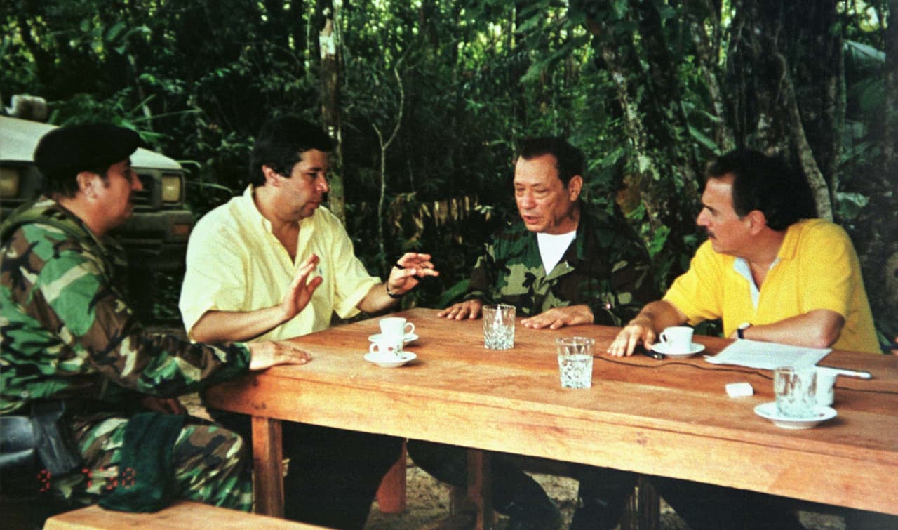 <b>El histórico encuentro entre un presidente colombiano y el líder de las Farc en la selva</b>. En un época donde más de 200 integrantes del Ejército y la policía habían sido secuestrados, comenzó un diálogo entre las Farc y gobierno del entonces presidente Andrés Pastrana. Era 1999 y el gobierno accedió a desmilitarizar unas 26,000 millas (42,000 kilómetros) para adelantar las conversaciones. Este intento de pacificación fracasó. En la histórica foto (de izq a der): El Mono Jojoy, Víctor Ricardo (Alto Comisionado para la Paz), Marulanda y Pastrana.