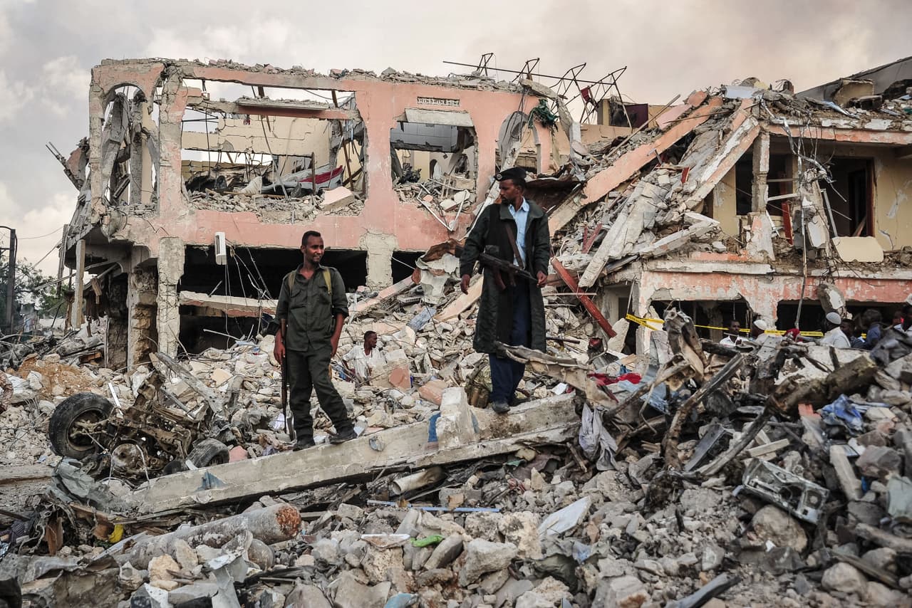 Oficiales de seguridad somalíes patrullan en la escena de la explosión.