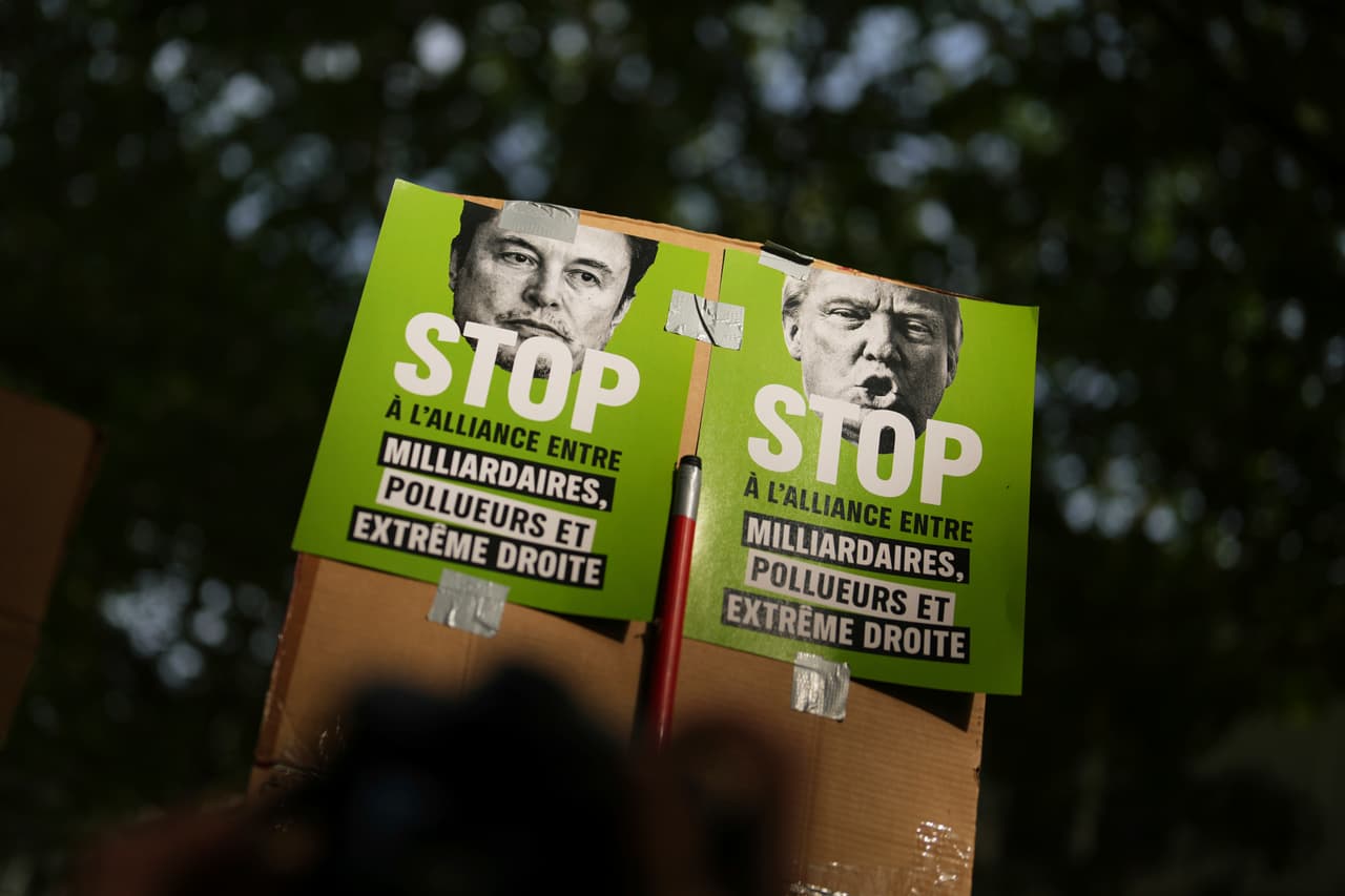 Manifestantes sostienen carteles en contra de Elon Musk, izquierda, y del presidente Donald Trump durante la manifestación del Primero de Mayo, el jueves 1 de mayo de 2025, en París. 
<br>