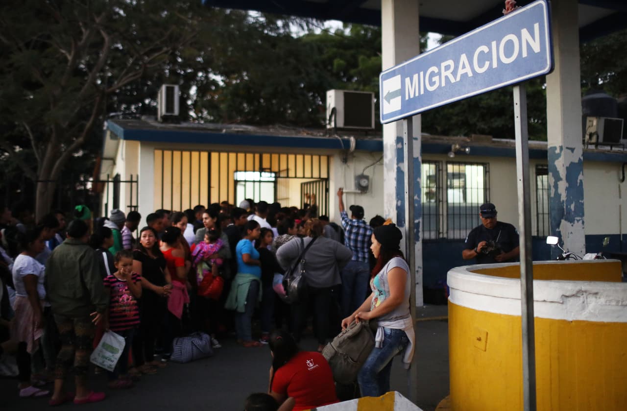 La gente de una caravana de migrantes centroamericanos espera en fila para cruzar la frontera Guatemala-México y se registra en una oficina de inmigración en México el 19 de enero de 2019 en Tecun Uman, Guatemala.