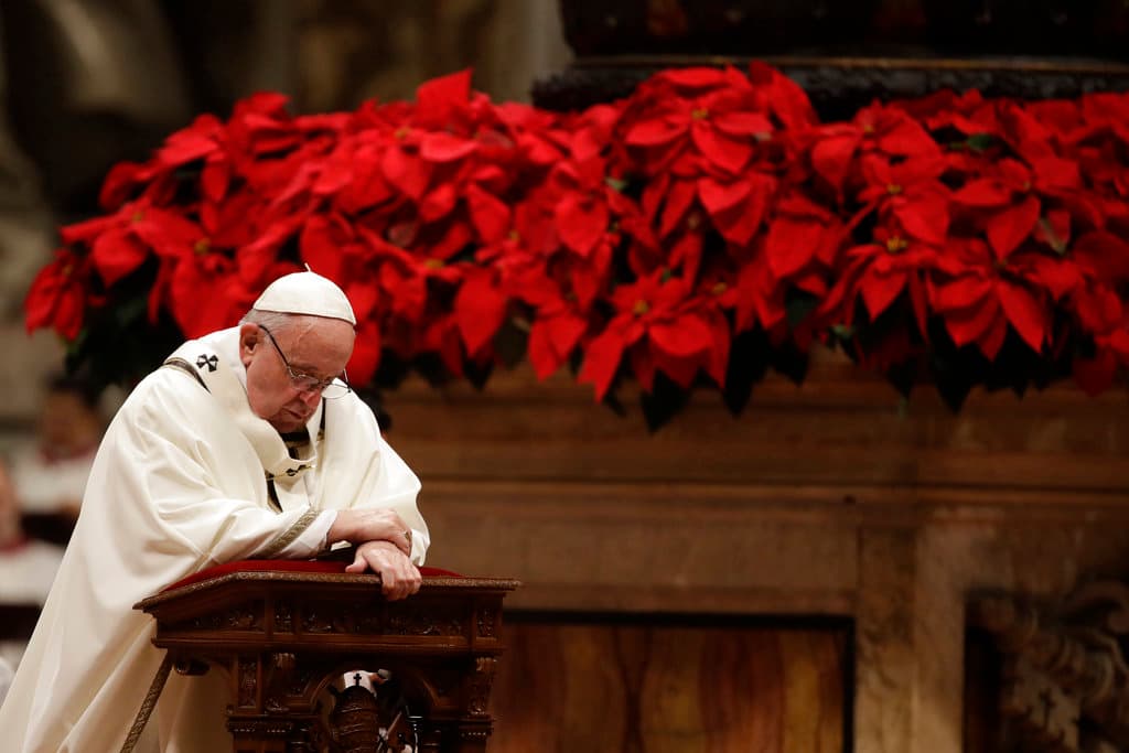 El papa Francisco hincado ante el altar mientras ofrece la misa de Nochebuena en la Basílica de San Pedro este lunes 24 de diciembre de 2018.
