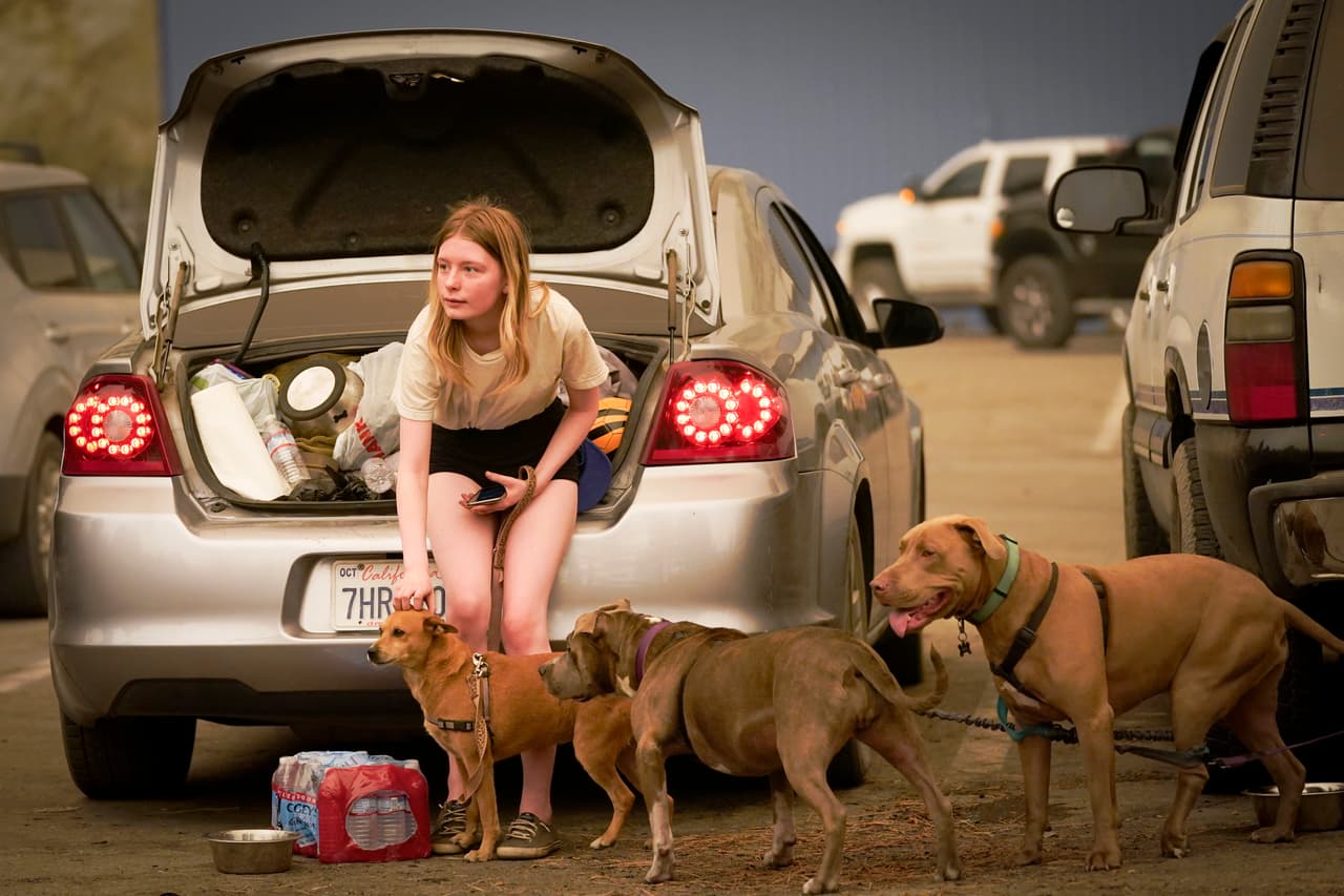 Kelsey Mueller, de 16 años, habitante de Armona, California, 
<b>acaricia a sus perros mientras espera con su familia ser escoltada </b>desde la montaña mientras el incendio de Creek arde cerca en Shaver Lake, California.
<br>