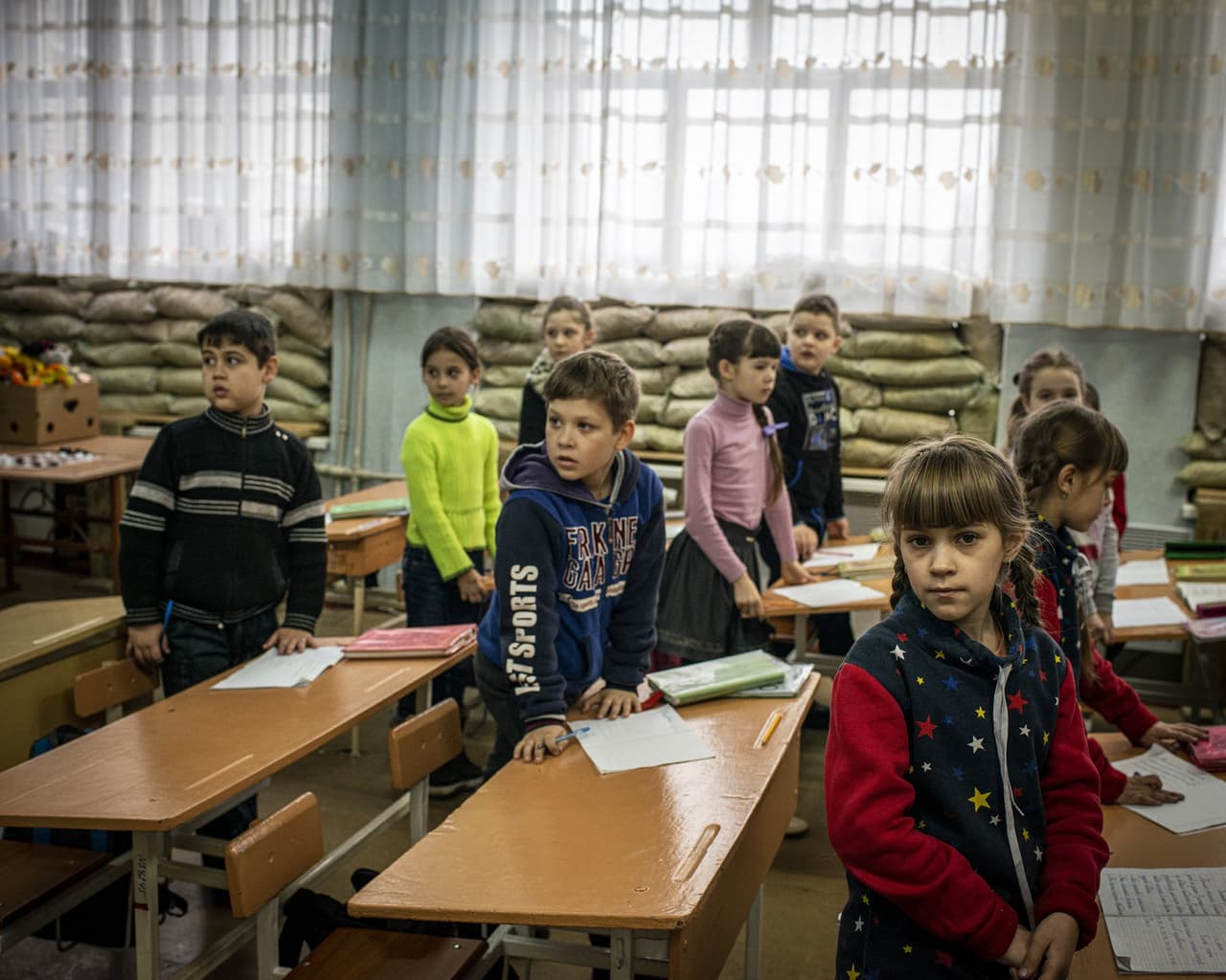 Un grupo de niños en su salón de clases en una escuela en la plaza Lenin, en Marinka, Donbas. El centro permaneció abierto durante el conflicto entre los grupos separatistas y las fuerzas del gobierno de Ucrania en la región.