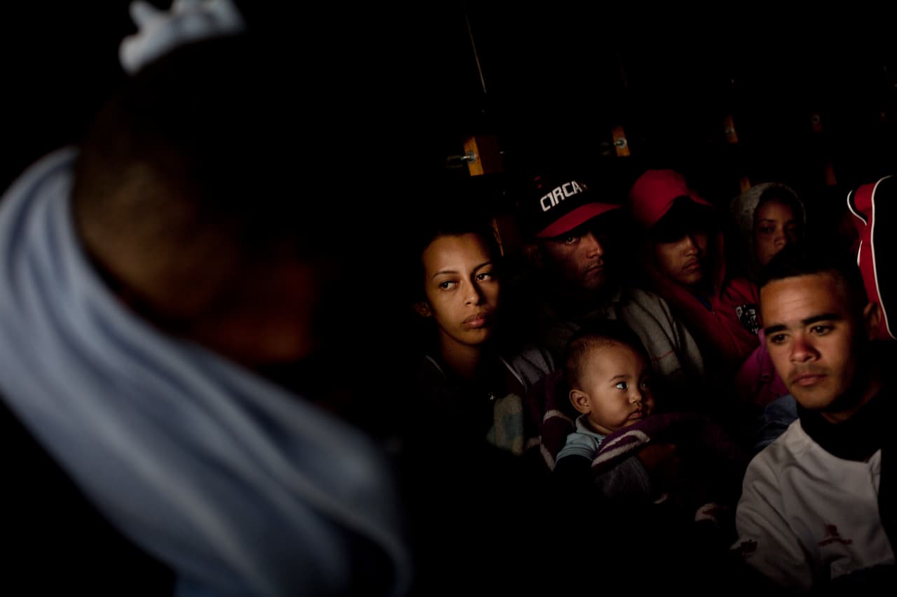 Un grupo de migrantes venezolanos viaja en la cabina de carga de un camión que se dirige a la frontera entre Ecuador y Colombia.