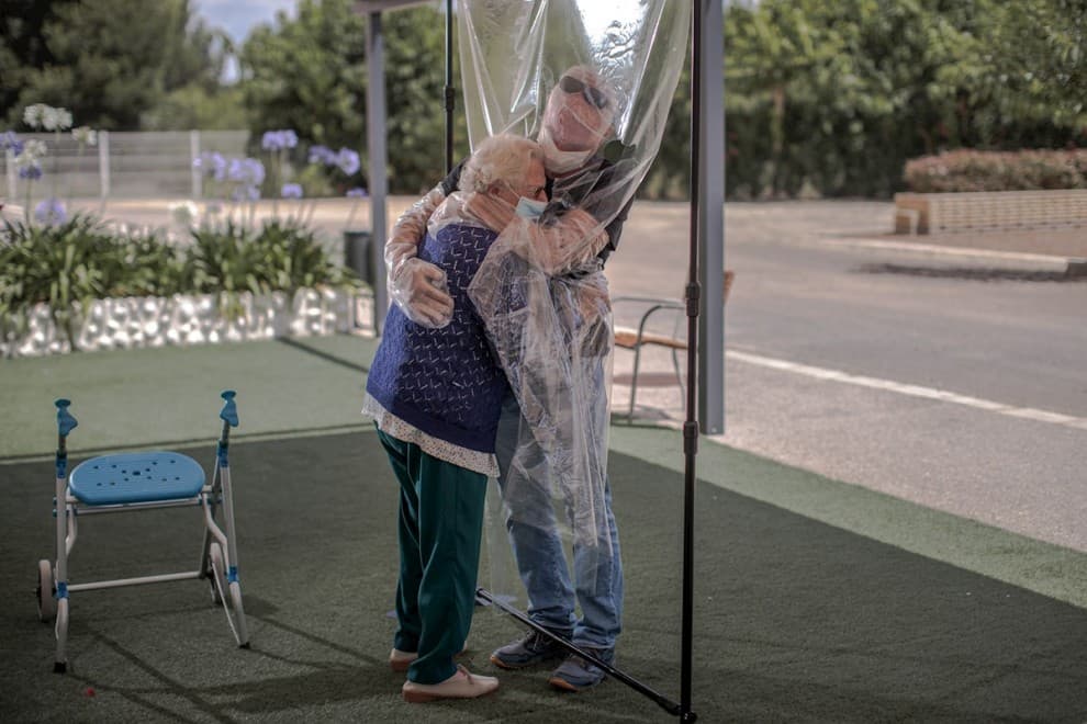"Está siendo muy emotivo y muy bonito, porque es el primer reencuentro cercano", señala el director del centro de Valencia, Jesús Alcázar. Un hijo abraza a su padre quien decide levantarse de su andadera para entrar en contacto con él.