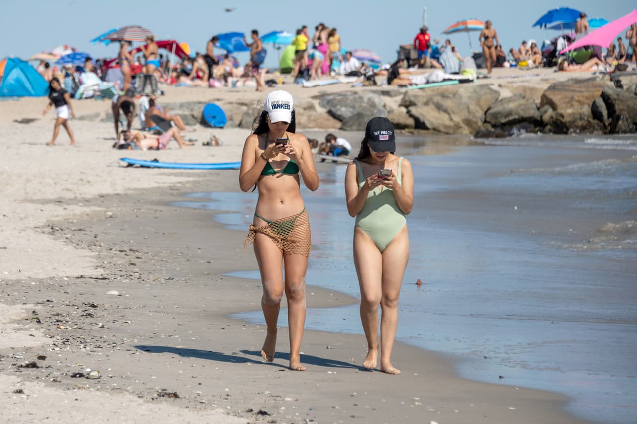 <b>Rockaway Beach- Queens</b>
<br>8601 Shore Front Pkwy,
<br>Rockaway Park – 
<br>Tel.
<b> </b>(718) 318-4000
<br>
<a href="https://www.google.com/maps/dir/Rockaway+Beach,+Queens,+NY/@40.5861316,-73.8866665,12z/data=!4m9!4m8!1m0!1m5!1m1!1s0x89c26876363711a3:0xe5c433c345d63995!2m2!1d-73.8166259!2d40.5860224!3e0">Cómo llegar</a>
<br>Si vas a Rockaway Beach, no es necesario que andes cargando con tus refrigerios: en sus alrededores hay muchos carritos de comida, como el popular “Italian ice”, ¡y muy buenos tacos! 
<br>
<br>
<b>Muchos van a Rockaway para practicar el surf, </b>pero si no sabes hacerlo, no te preocupes: hay instructores para ello (claro, tienes que pagar). Y, para los amantes de compras, hay una variedad de tiendas, pero no solo de artículos de playas, también de curiosidades.
<br>