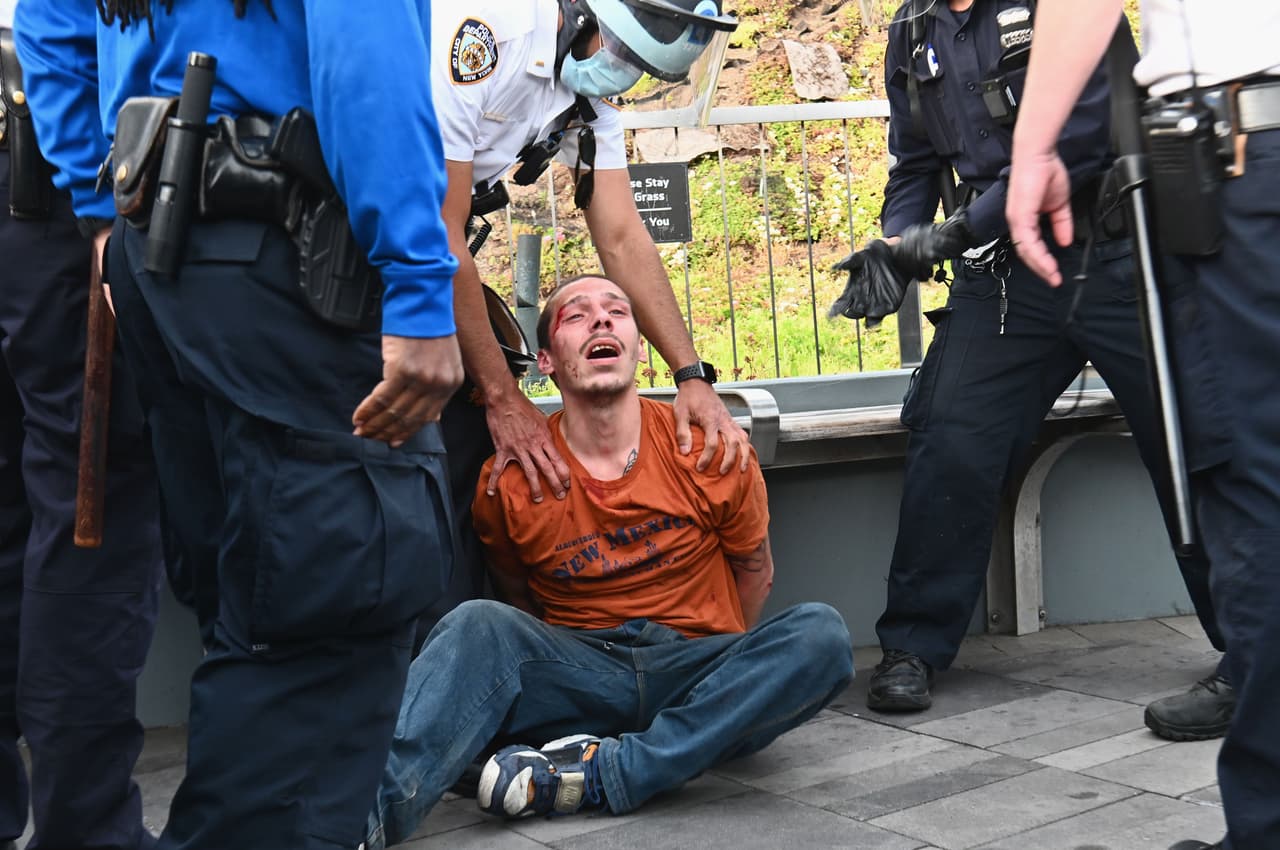 La policía de Nueva York arresta a un manifestante durante una protesta del movimiento 'Black Lives Matter' (La vida de los negros importa) por la muerte de George Floyd a manos de un policía de Minneapolis. El alcalde de Nueva York, Bill de Blasio, declaró este lunes un toque de queda de 11:00 pm a 5:00 am, debido a que las protestas pacíficas han derivado en brotes violentos que causan destrozos a la ciudad y a muchos negocios.
