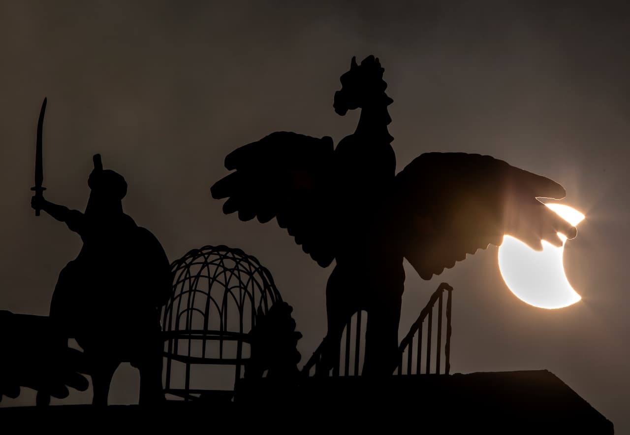 Una imagen del eclipse detrás de unas estatuas en Islamabad, Pakistán.