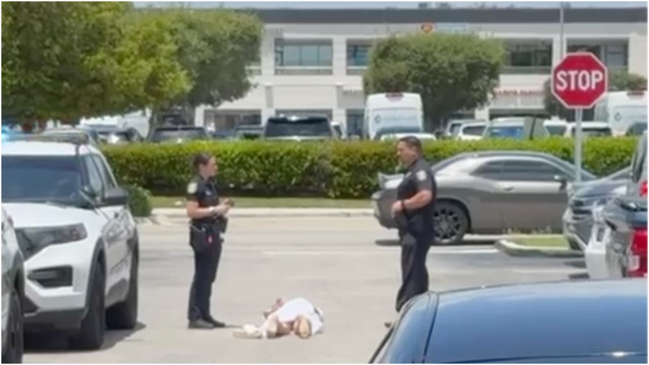 La mujer se acostó en el suelo del estacionamiento del centro comercial.