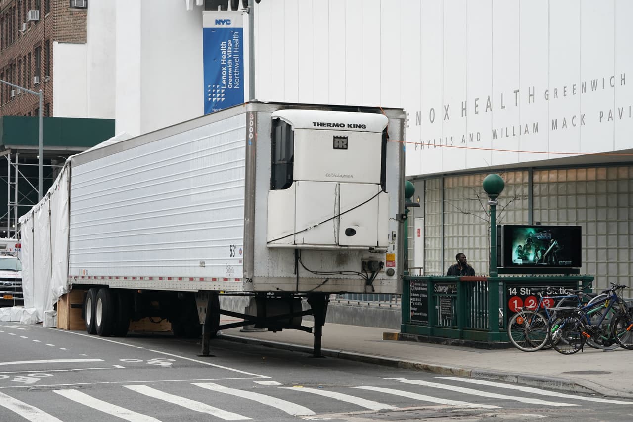 Camiones que funcionaran como morgues ambulantes que se ven en la salida del Hospital Lenox en el bajo Manhattan para alojar las víctimas del coronavirus.