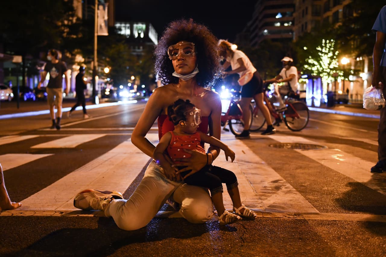 <b>La protesta de todos.</b> Twana Buck y su hija Bonita se sientan en una calle cerca de la Casa Blanca, durante una de las manifestaciones por la muerte de Floyd el 23 de junio.