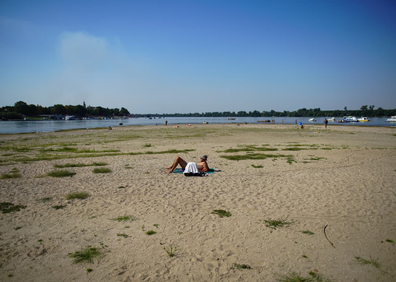 Un hombre toma el sol a orillas del río Danubio, en Belgrado.