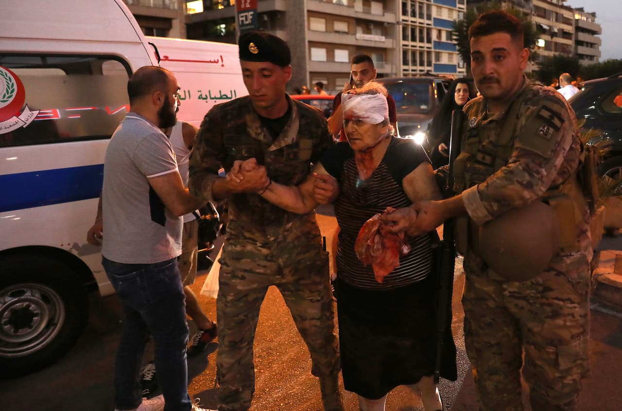 Una mujer herida recibe ayuda en la entrada de un hospital.
<br>