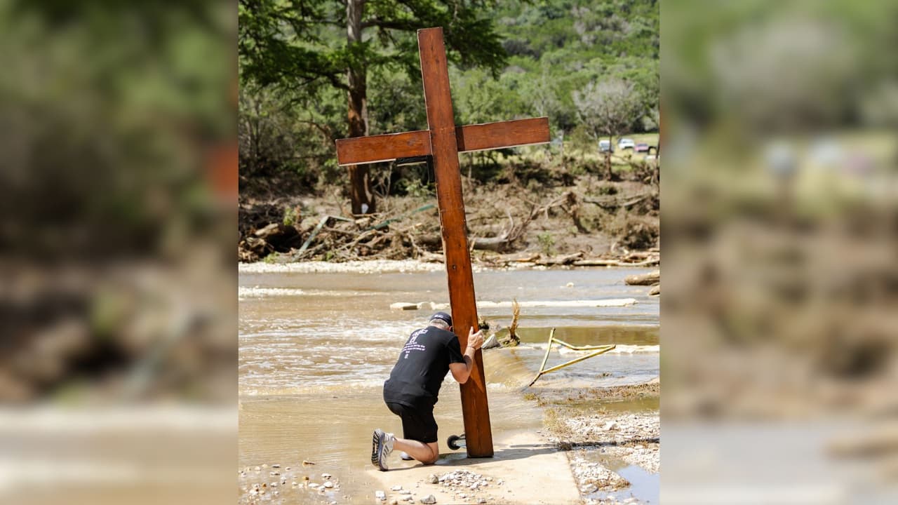 Esperanza en medio de la tragedia: hombre lleva cruz gigante al río Guadalupe para orar por las víctimas