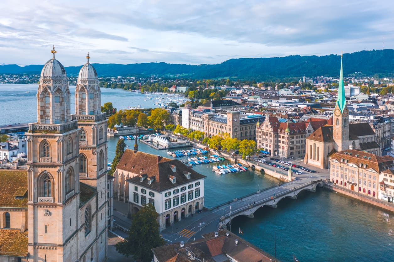 <b>6. Zurich, Suiza:</b> Es la mayor y más poblada ciudad de Suiza y también ha llegado a encabezar la lista, tanto de las más caras del mundo como de las de mejores condiciones de vida y más altos salarios. Está ubicada en las riveras del lago del mismo nombre y en el horizonte se pueden ver los Alpes, por lo que ofrece un entorno natural muy atractivo. Tiene más de 430,000 habitantes.
<br>
<br>
<b>Mira como quedó el ránkin del año pasado:</b> 
<b><a href="https://www.univision.com/noticias/dinero/inflacion-precios-pandemia-costo-de-vida-ciudades-mundo-2021-fotos">Las ciudades más baratas y caras del mundo en 2021.</a></b>