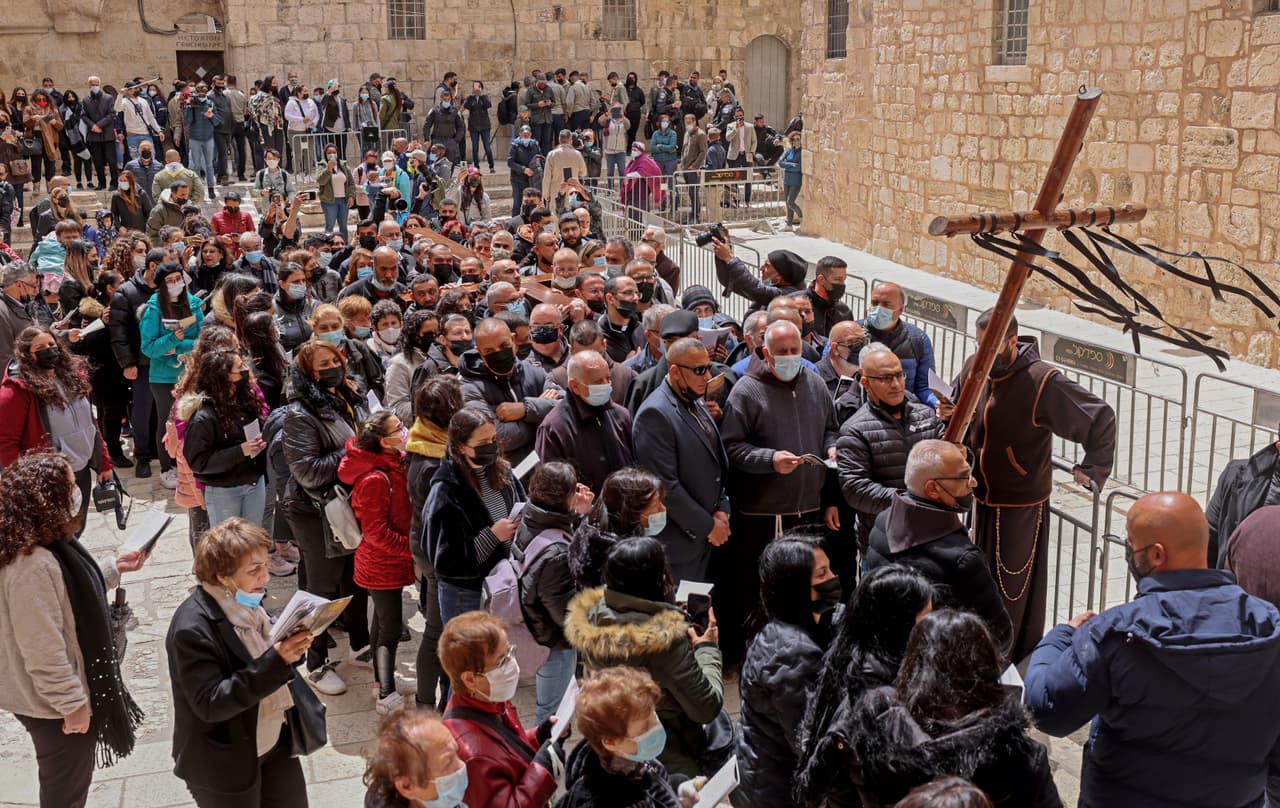 Un grupo de cristianos llegan a la Iglesia del Santo Sepulcro de Jerusalén, cargando una cruz de madera. Esta iglesia fue construida en el lugar en el que los cristianos creen que Jesús fue crucificado, murió y resucitó de entre los muertos. Este año está abierta con limitaciones, los visitantes deben llevar mascarilla y guardar distancia.
<br>