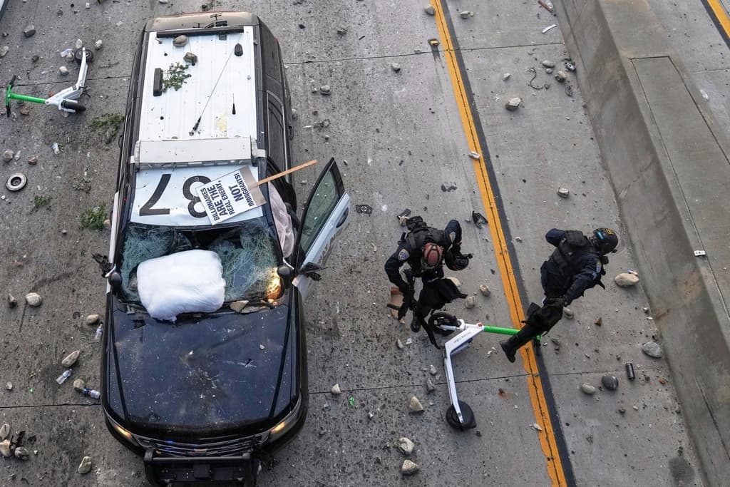 Agentes de la Patrulla de Caminos de California (CHP) tuvieron que huir de las piedras y de la 'scooter' que arrojaron manifestantes desde el puente más cercano al Centro de Detención de ICE, en Los Ángeles.