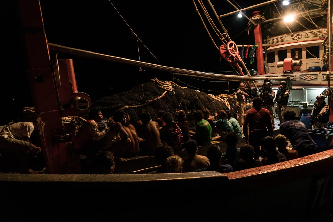 Cambodian migrant workers on a Thai fishing ship wait during an inspection.
<br>