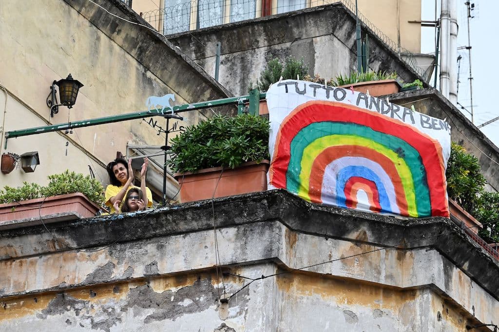 La gente saluda y aplaude junto a una pancarta que dice "#andratuttobene" (# Todo Va a Estar Bien) en Roma. Las personas solo pueden salir de casa cuando es estrictamente necesario.
<br>