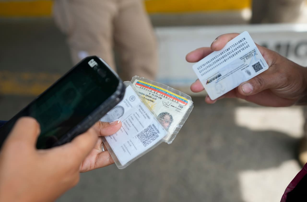 Un oficial de migración colombiano verifica las identificaciones de una mujer antes de que cruce el Puente Internacional Simón Bolívar. 
<b>La extensa región fronteriza de 2,200 kilómetros entre Colombia y Venezuela está unida por puentes que los conectan legalmente. Sin embargo, a lo largo de ella hay decenas de pasos ilegales -también llamados trochas- por donde suele circular el contrabando con todo tipo de productos, entre ellos los más básicos que requiere Venezuela, y los grupos ilegales se disputan el control del tráfico de armas, de drogas y la trata de personas.</b>
<br>
<br>
<br>
