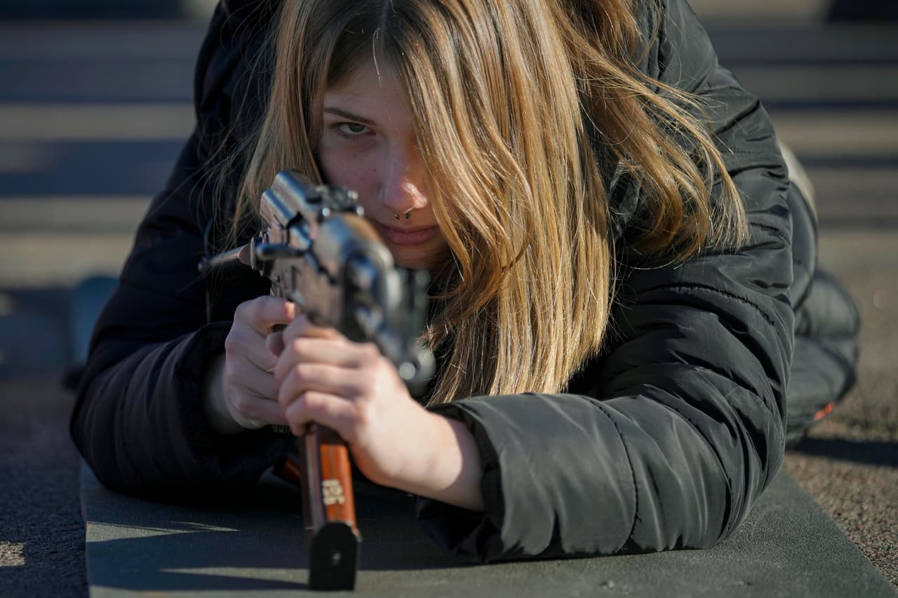 Una mujer usa un arma durante una sesión de entrenamiento para civiles, organizada por la Unidad de Fuerzas Especiales Azov en Mariupol, en la región de Donetsk del este del país.