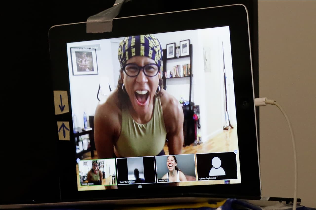 <b>Motivación a través de la pantalla.</b> Tamara Jackson, instructora física de Nueva York, realiza desde casa una sesión de entrenamiento con sus alumnos, conectados a través de Zoom. Según analistas citados por Business Insider, algunas aplicaciones de videollamada han tenido un aumento de las descargas de más del 1,000%, desde que declararon las primeras órdenes de cuarentena en EEUU. 25 de abril.
<br>