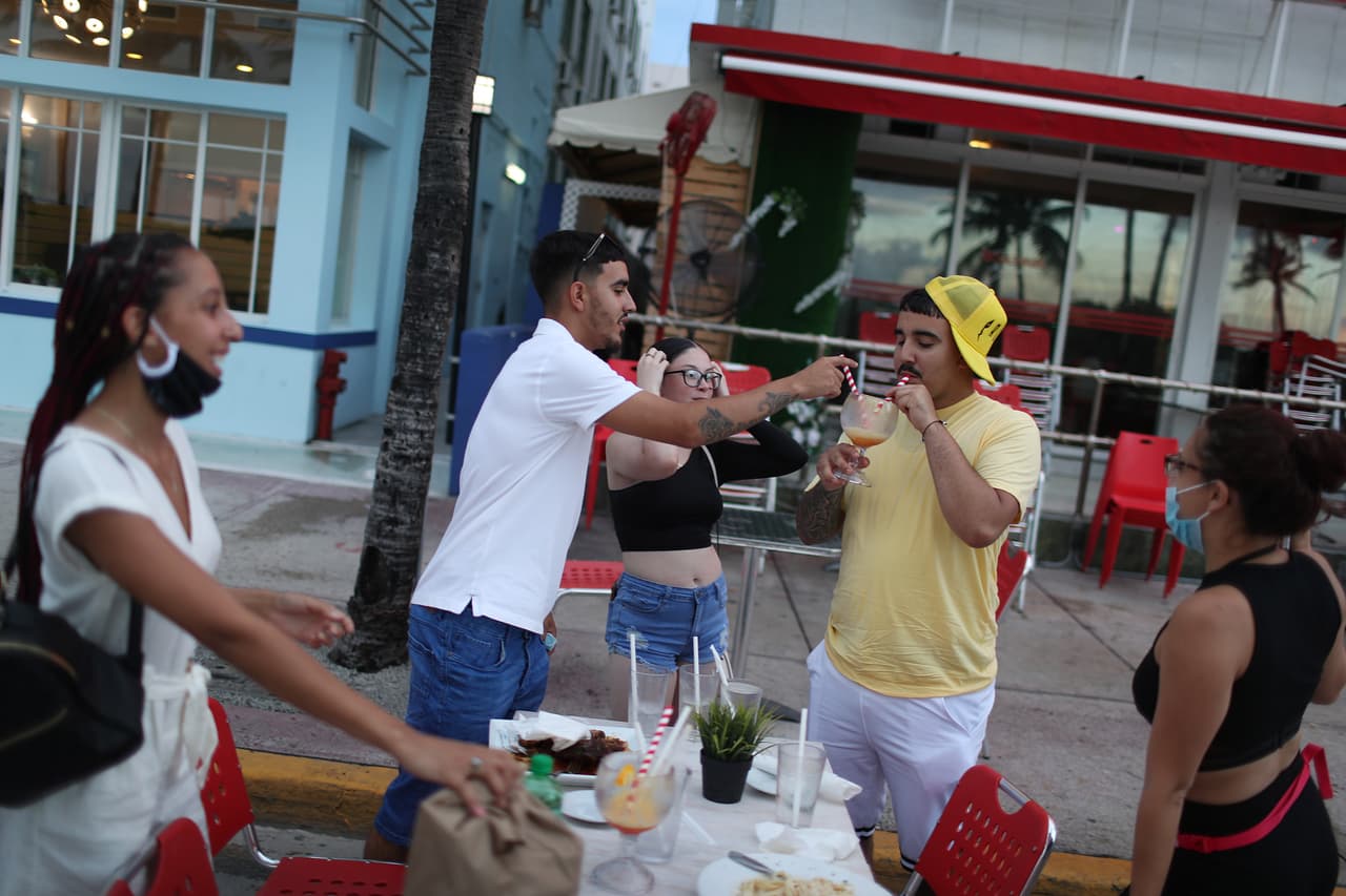 <b>Florida.</b> Clientes en un restaurante de Miami Beach el 18 de julio. 
<br>
<br>Tres semanas después de la suspensión de algunas medidas de protección a mediados de mayo, ya Florida se había convertido en uno de los focos principales de la pandemia en el país. El 26 de junio los bares fueron cerrados nuevamente, mientras que los restaurantes siguieron funcionando con limitaciones. Algunas autoridades locales agregaron otras normas, como el servicio limitado a las áreas exteriores de los negocios.