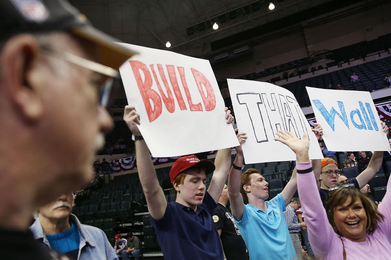 Seguidores de Trump con un cartel de "Construyan el muro"
