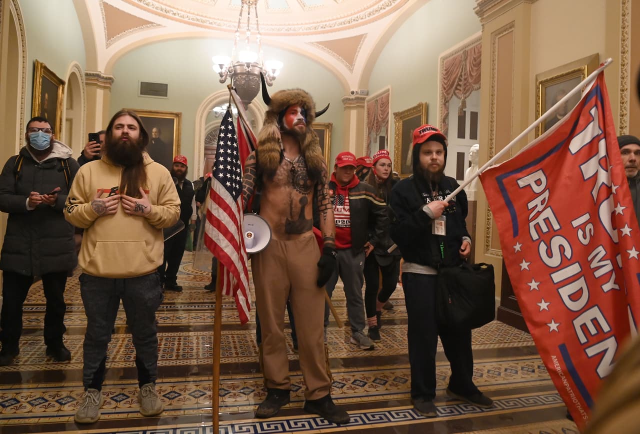 Los partidarios del presidente de los Estados Unidos, 
<b>Donald Trump</b>, incluido miembros del grupo de conspiración 
<b>QAnon</b>, 
<b>Jake Angeli</b>, también conocido como Yellowstone Wolf, ingresan al 
<b>Capitolio de Estados Unidos</b> el 6 de enero de 2021 en Washington, DC. Los manifestantes violaron la seguridad y entraron mientras el Congreso debatía la Certificación de Voto Electoral para las elecciones presidenciales de 2020.