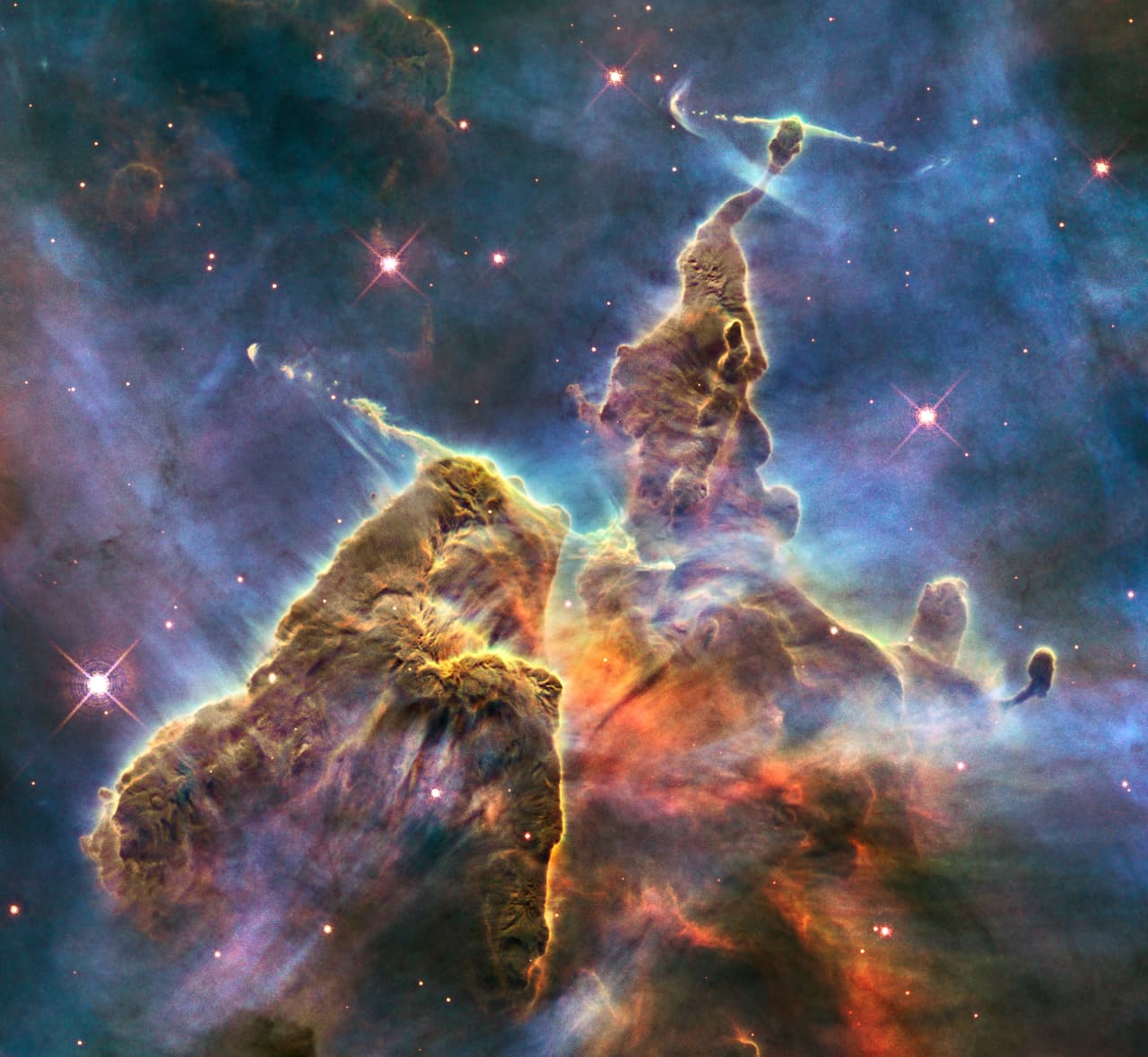 <b>Montaña mística (2010). </b>Esta imagen del Hubble captura la actividad caótica en la cima de un pilar de gas y polvo. El pilar también es 'roto' desde adentro, ya que las estrellas jóvenes en su interior expulsan chorros de gas que se pueden ver fluyendo.
