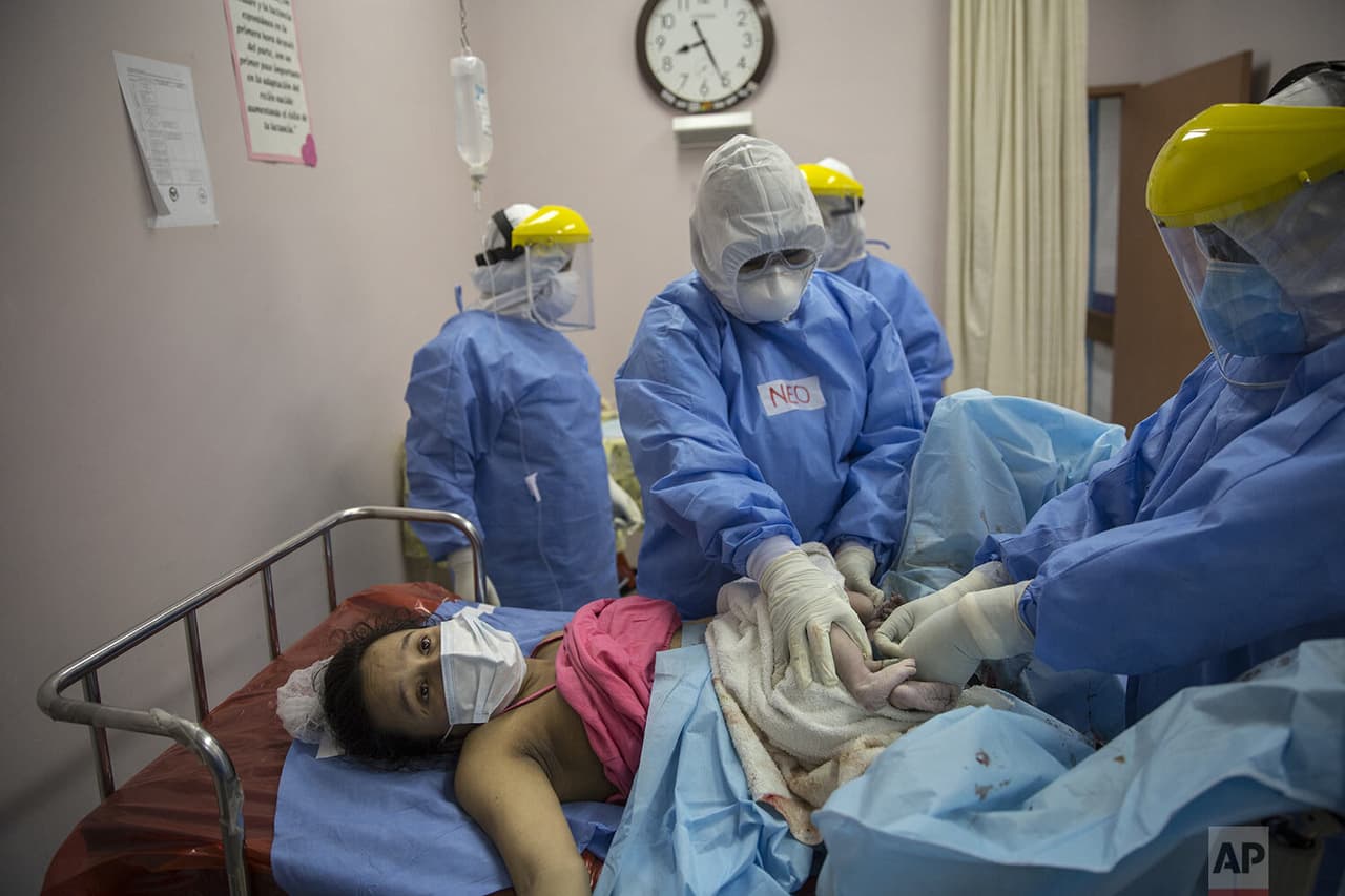 María Álvarez agotada espera que le entreguen a su bebé recién nacida
<b> mientras un obstetra y neonatólogo sujetan el cordón umbilical de la recién nacida.</b>
<br>