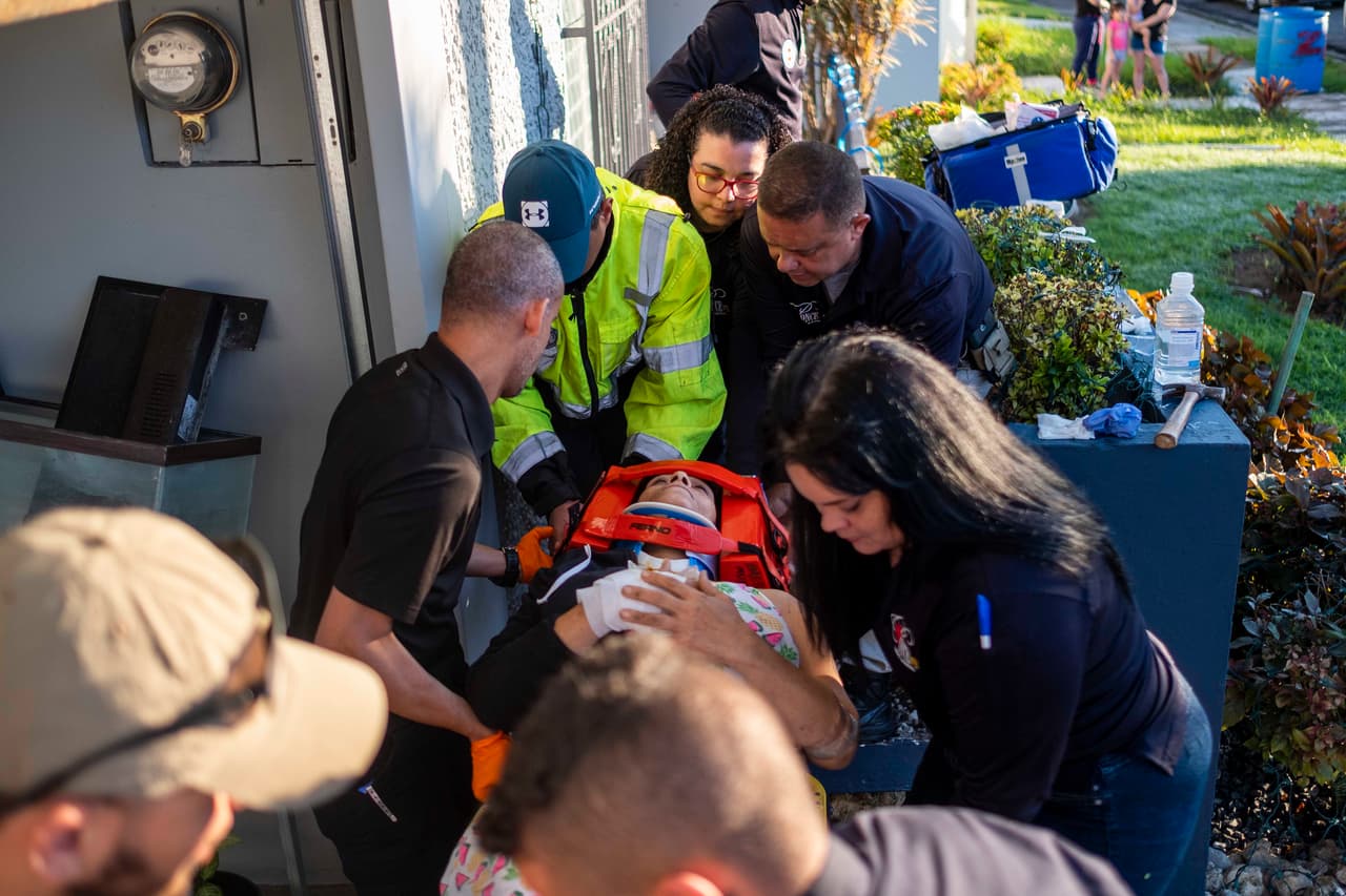 Paramédicos atienden a una mujer que resultó herida en Ponce, en pueblo en el sur de Puerto Rico, luego de que un sismo de magnitud 6.4 estremeciera la isla en la mañana de martes.