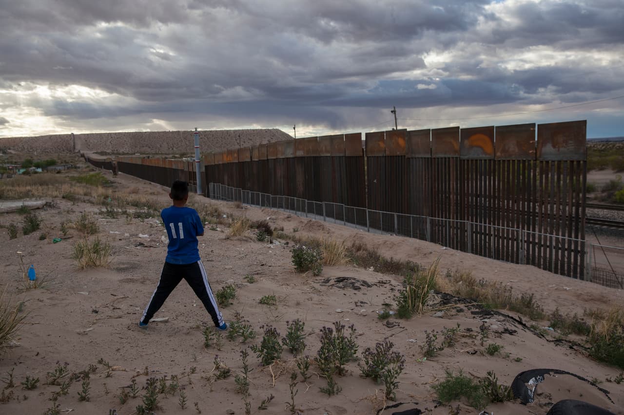 Un niño mira la nueva valla fronteriza que remplaza una más baja en Anapra un vecindario de Ciudad Juárez, México, 29 de marzo de 2017.
