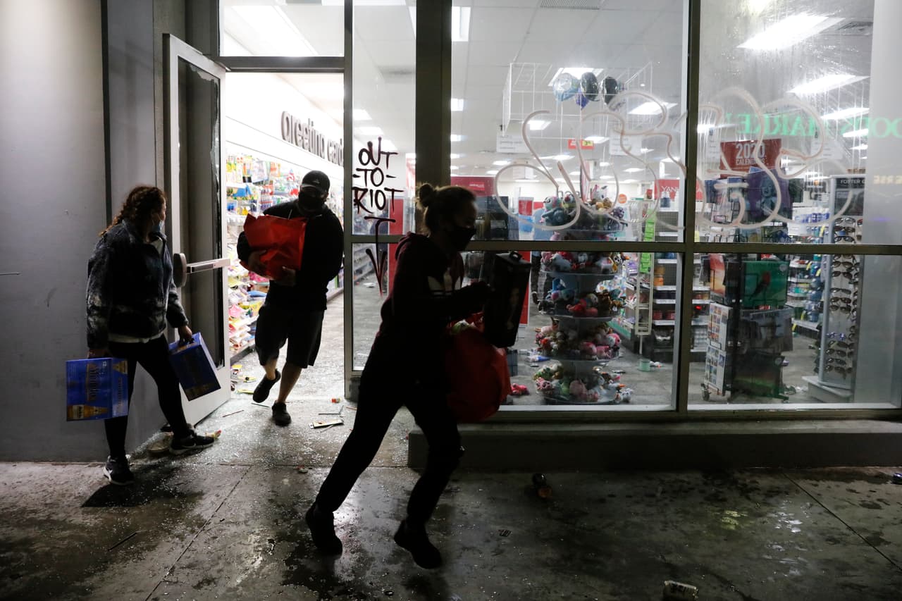 Un grupoo saquea una tienda CVS durante una protesta en la madrugada del sábado 30 de mayo.