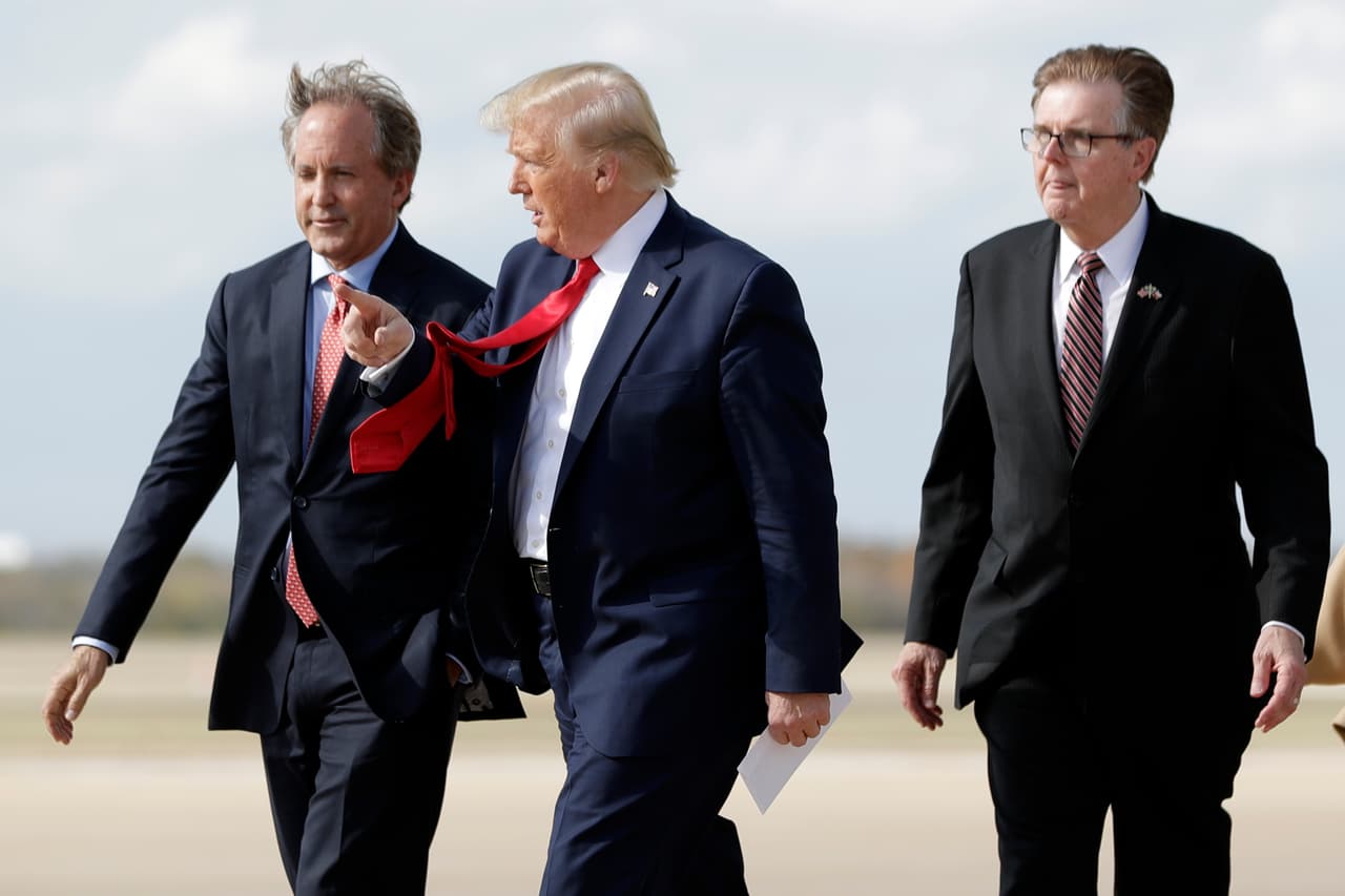 La demanda fue presentada por el fiscal general de Texas, Ken Paxton, quien actualmente es investigado por el FBI por sobornos y abuso de poder en favor de un empresario donante de su campaña. Paxton (quien aparece a la izquierda de la imagen junto con Trump y el vicegobernador Dan Patrick) sostiene que los estados que demanda no respetaron la Constitución al extender el alcance del voto por correo pese al coronavirus. El fiscal lo ha hecho a unos días de que el Colegio Electoral oficialice la victoria de Joe Biden.