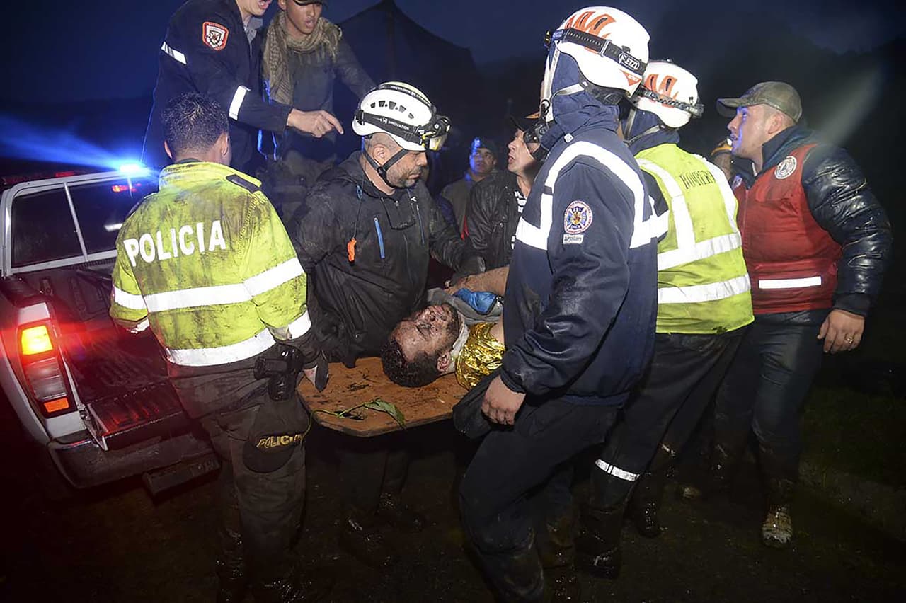 Equipo de rescate transportan a uno de los supervivientes del accidente de avión.