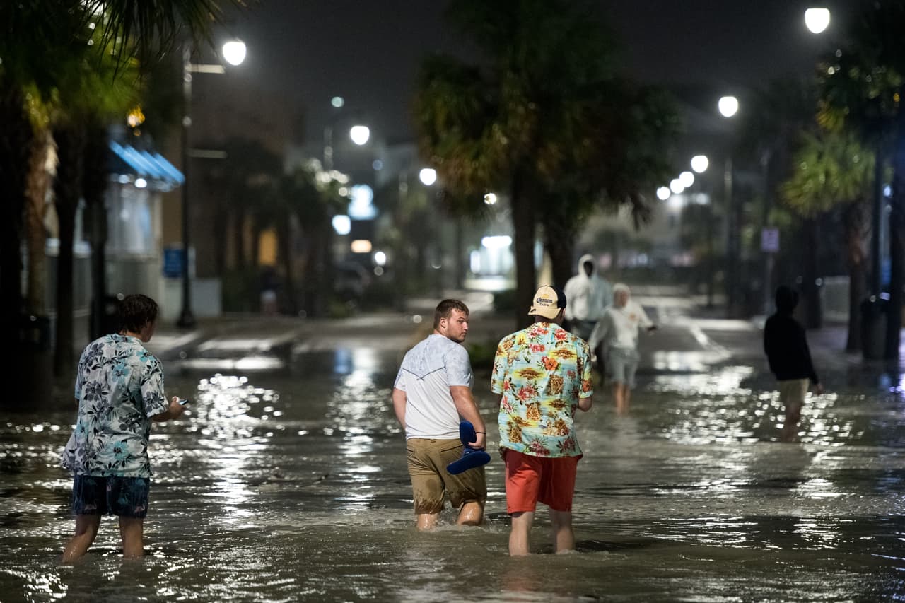 Personas caminando por el inundado bulevar Ocean, en Myrtle Beach, Carolina del Sur.