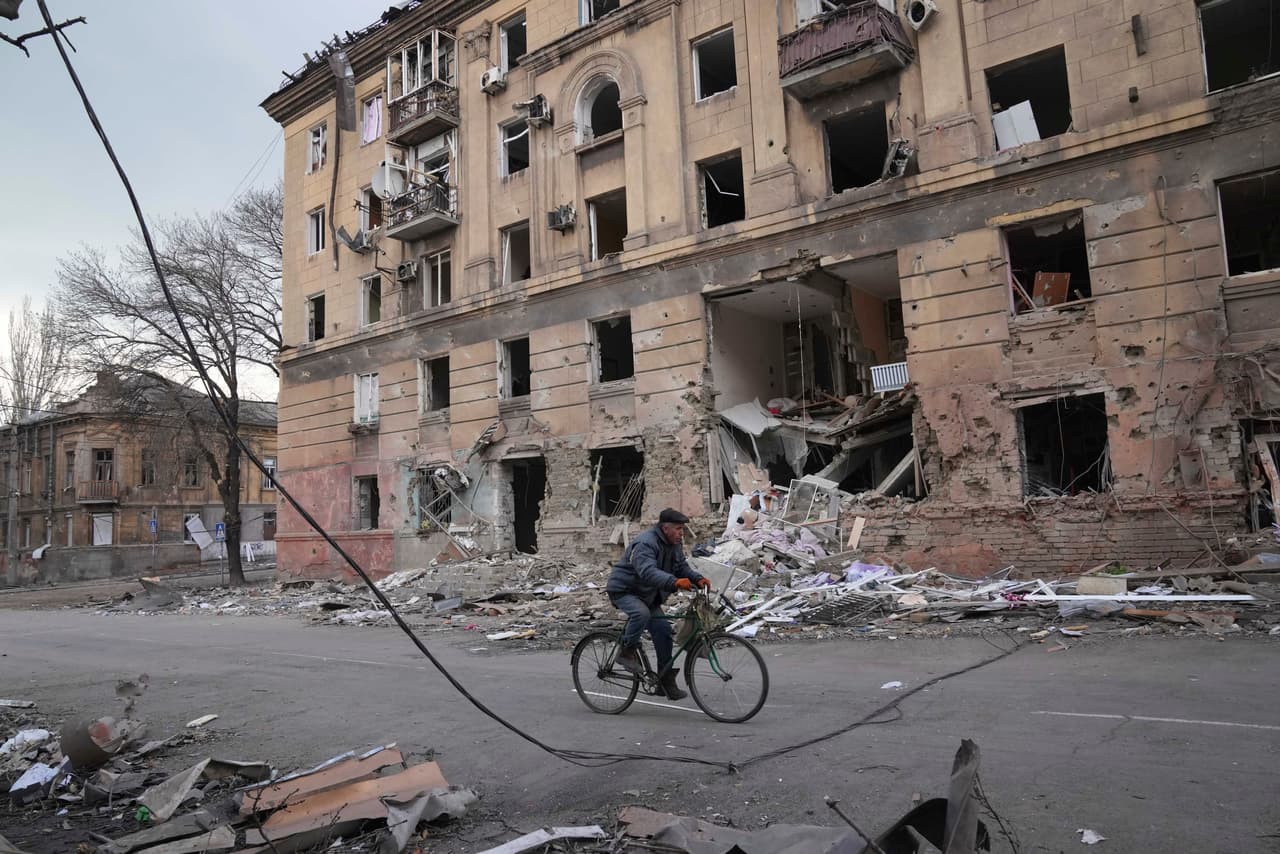 Un hombre recorre una calle de Mariupol a bordo de una bicicleta. Antes del bombardeo contra el hospital, Rusia había dicho que permitiría instalar corredores humanitarios en la ciudad, llamada "la capital del acero" de Ucrania, para permitir el escape de civiles.
