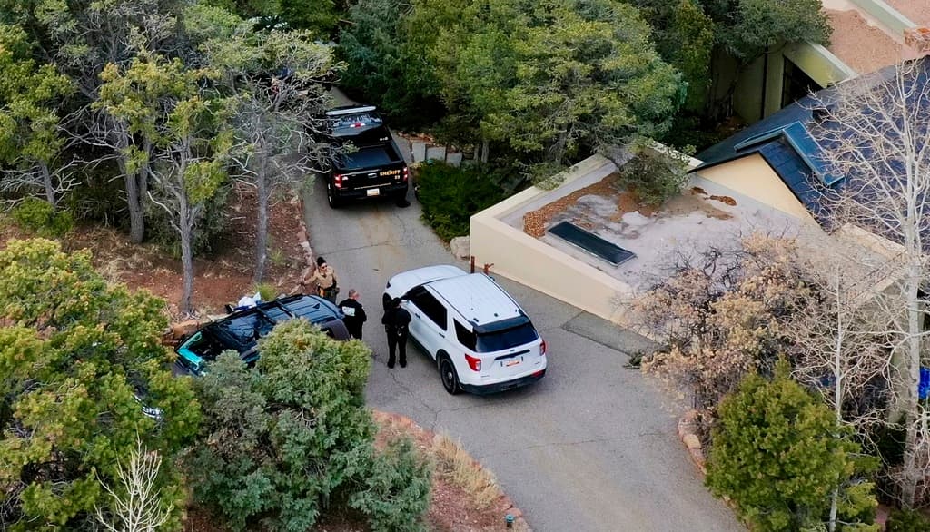 Agentes de la ley hablan afuera de la casa del actor Gene Hackman el jueves 27 de febrero de 2025 en Santa Fe, Nuevo México. Hackman, su esposa Betsy Arakawa y su perro, fueron encontrados muertos en la casa un día antes.